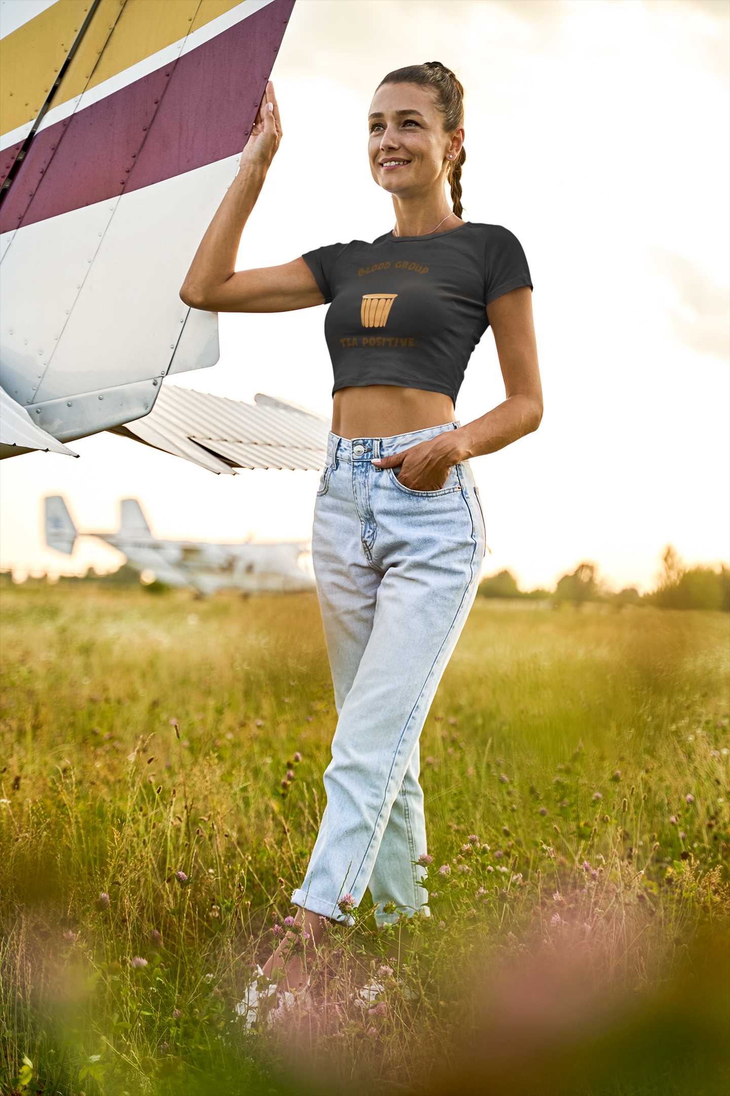 crop-top-mockup-featuring-a-woman-standing-next-to-a-light-aircraft-m15738-r-el2